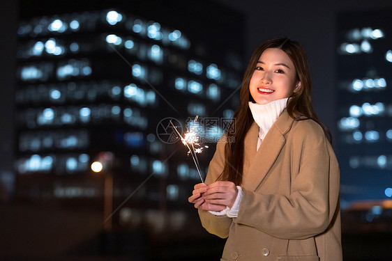 秋冬夜晚美女室外放烟花图片