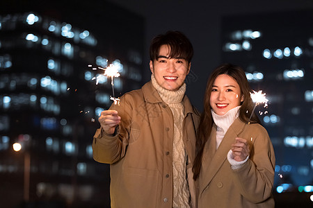 秋冬夜晚情侣室外放烟花迎新年背景