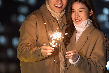 秋冬夜晚情侣室外放烟花特写高清图片