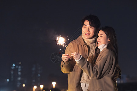 亲密情侣秋冬夜晚约会燃放烟花图片素材