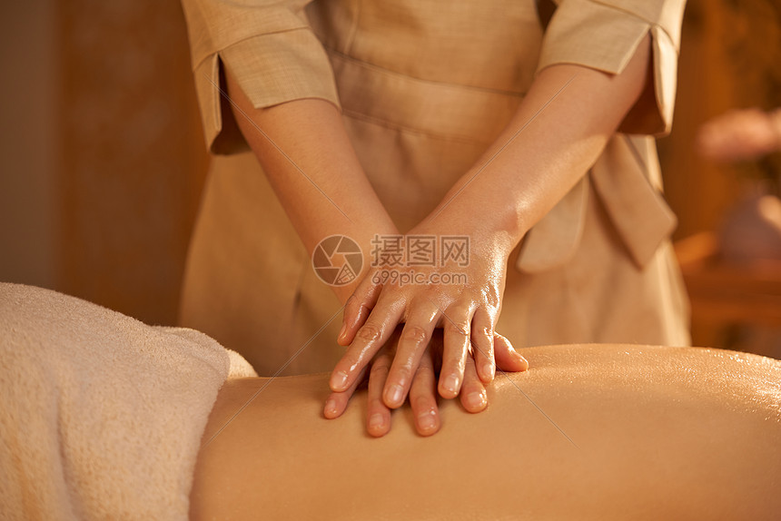 女性spa技师背部精油按摩图片