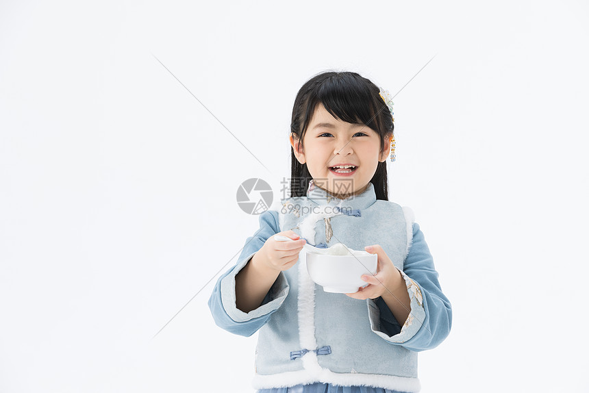 穿着淡蓝色古装的可爱小女孩开心地吃着汤圆图片