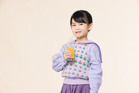 小女孩手里拿着一杯橙汁图片