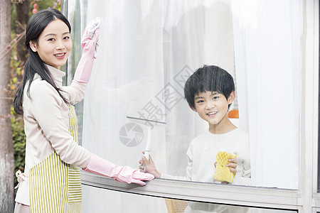 家庭大扫除擦拭窗户玻璃的母子图片