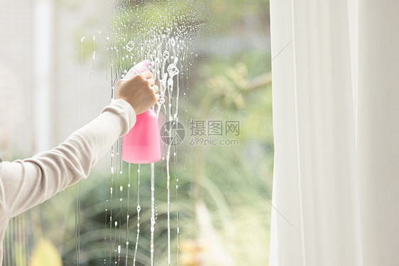 家庭主妇打扫卫生擦玻璃特写图片