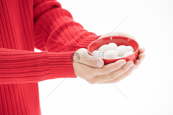 穿红色毛衣的手捧着汤圆图片