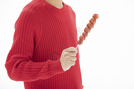 穿着红色毛衣的一双手拿着冰糖葫芦图片素材
