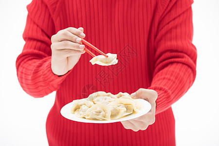 红色毛衣的手夹起饺子背景图片