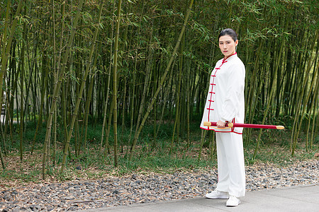 手拿着剑站在竹林边的女性图片