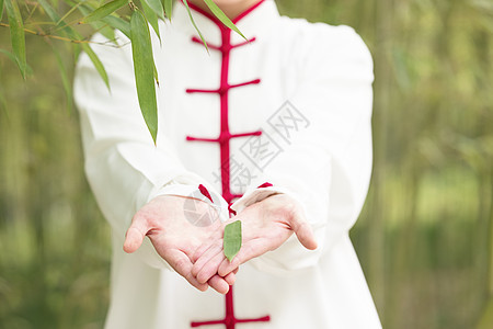 穿着练功服的女性手里捧着一片竹叶图片