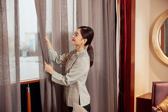 酒店服务保洁员整理窗帘图片