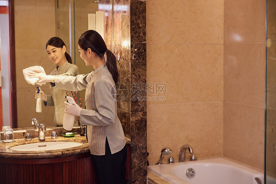 酒店保洁员整理清洁客房洗漱区域图片