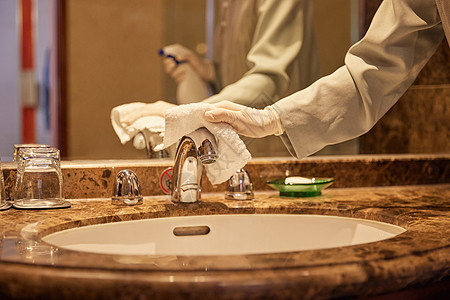 酒店保洁员整理清洁客房洗漱区域特写图片