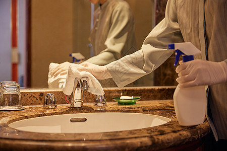 酒店保洁员整理清洁客房洗漱区域特写高清图片