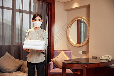 酒店服务佩戴口罩的保洁员更换毛巾图片