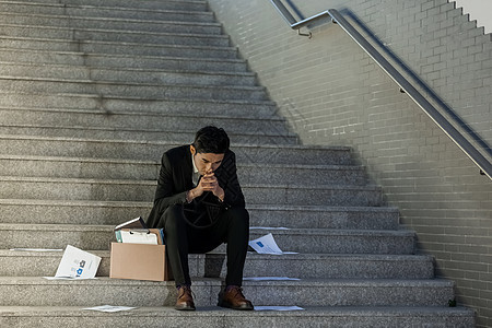 被辞退的商务男性失落的坐在楼梯上图片