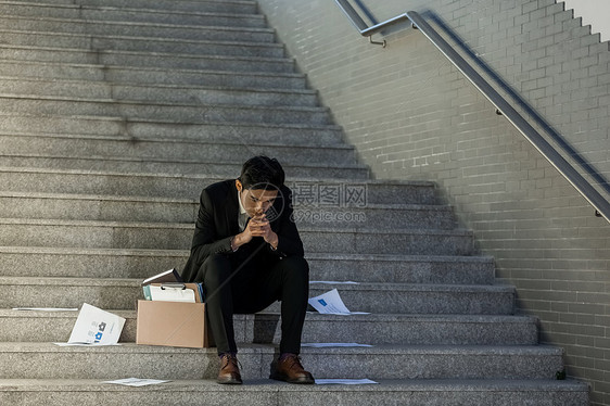 被辞退的商务男性失落的坐在楼梯上图片