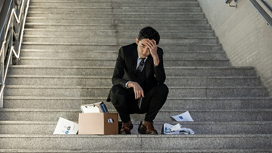 被辞退的商务男性失落的坐在楼梯上图片