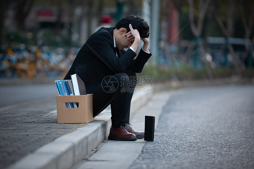 被辞退的男性失落的坐在街头图片