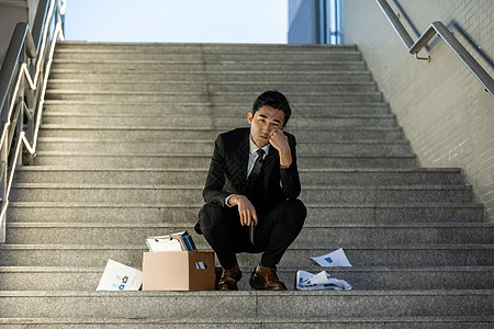 被辞退的商务男性失落的坐在楼梯上图片