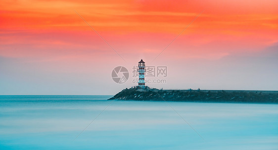 晚霞夕阳下的海边灯塔图片