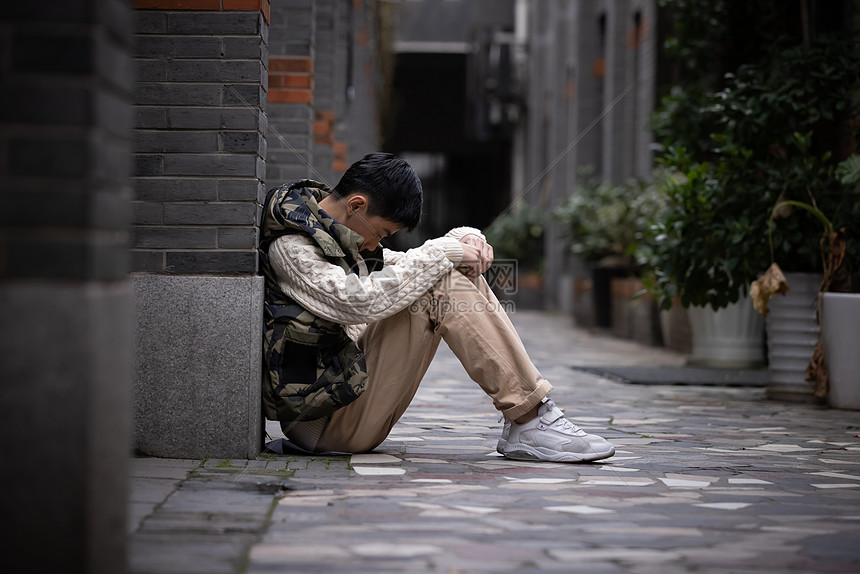 孤独的青少年遭受校园欺凌蜷缩在墙角