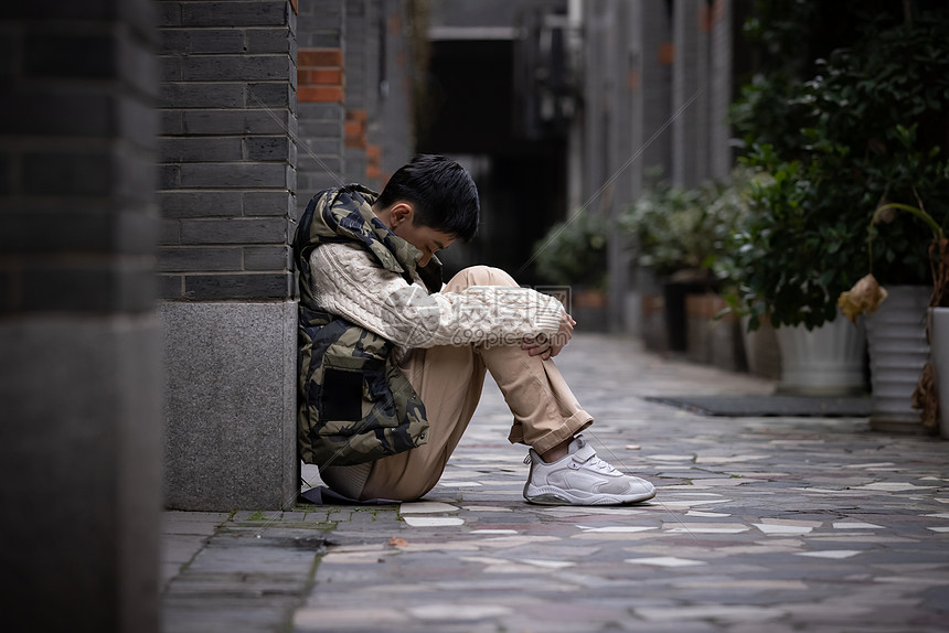 孤独自闭的青少年遭受校园欺凌蜷缩在墙角