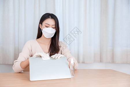 女性戴口罩居家办公清洁消毒图片