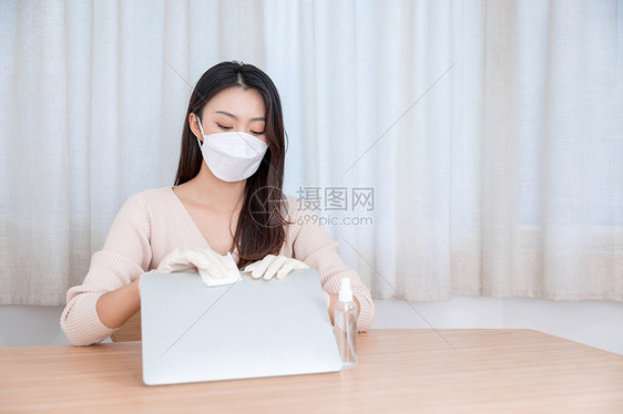 女性戴口罩居家办公清洁消毒图片
