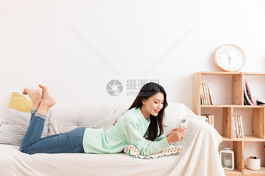 单身美女居家生活躺沙发上玩手机图片