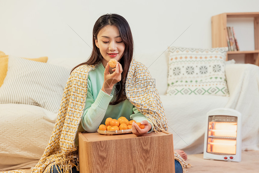 冬季暖炉保暖美女居家客厅吃橘子图片