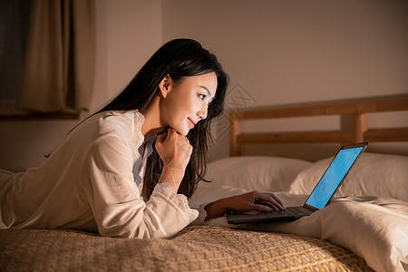 夜晚女性卧室里熬夜上网图片素材