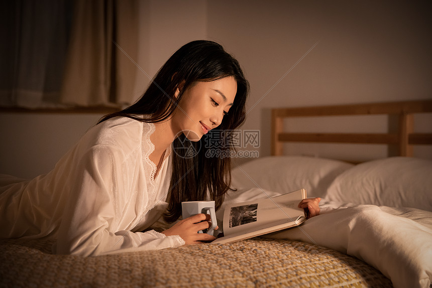 夜晚女性卧室里熬夜阅读看书图片
