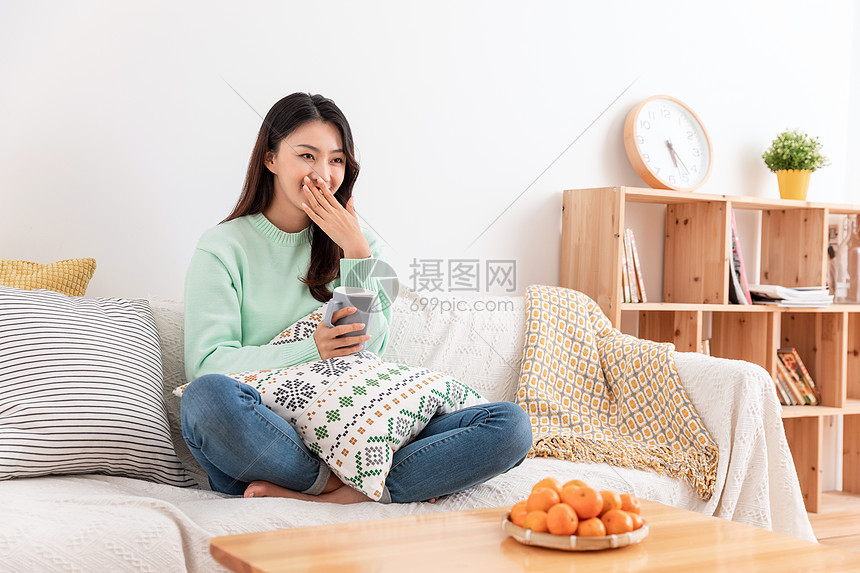 冬季美女独居沙发上看电视图片