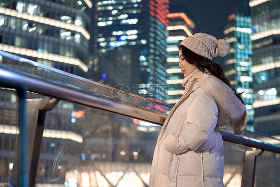 夜晚天桥上观赏城市夜景的女性图片