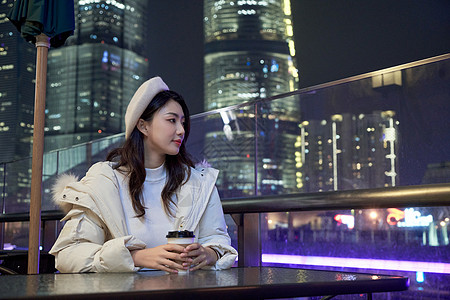 热咖啡城市景观夜晚坐在咖啡厅休息的都市女孩背景