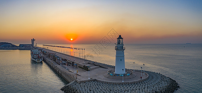 海埂大坝海上日出时的青岛情人坝和灯塔背景