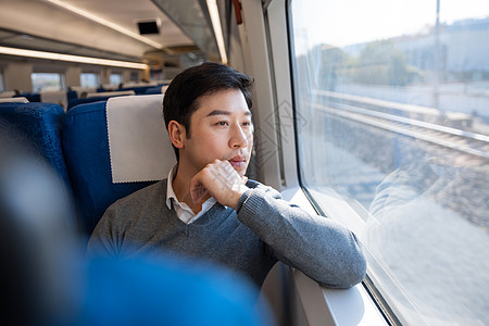 乘坐火车的男性看窗外风景图片