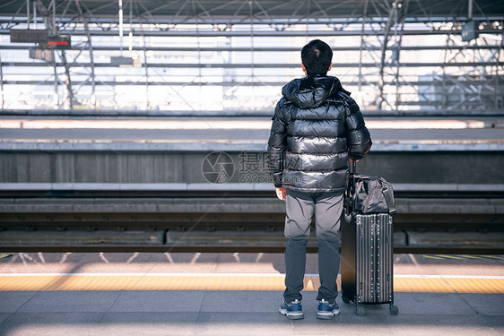 男性站在站台等待火车进站图片