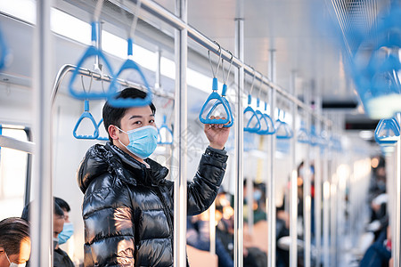 男性戴着口罩乘坐地铁图片