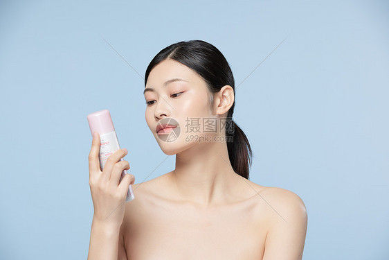 女性拿着防晒喷雾图片