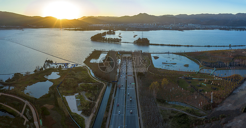 全景航拍昆明草海隧道口滇池日落风光图片