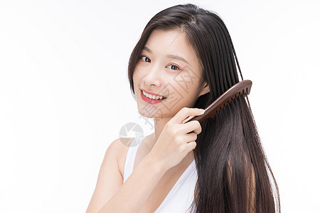 年轻女性使用梳子梳头发背景图片