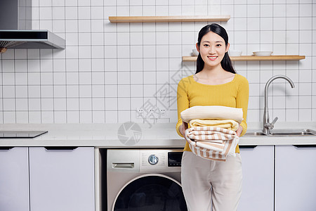 家庭主妇做家务抱着脏衣服高清图片