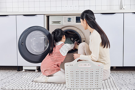 母女把衣物放进洗衣机清洗图片