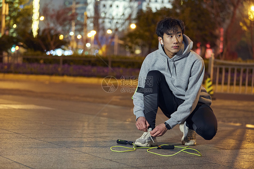 夜晚城市男性系鞋带准备跳绳图片