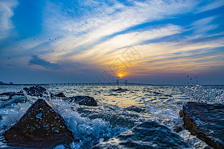 青岛胶州湾夕阳晚霞海上日落背景图片
