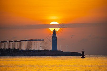 光线向上灯塔与海上日出背景