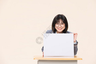 坐在课桌前展示白板的青春大学生图片