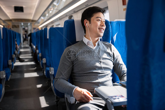 坐在火车上的男性看着窗外风景图片